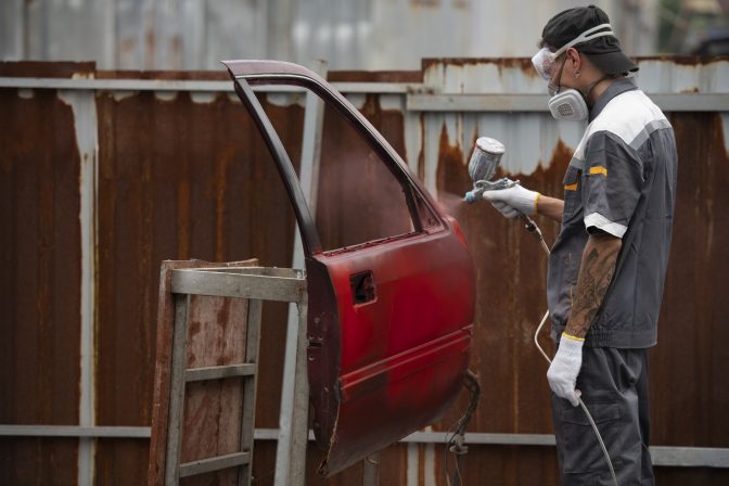 medium-shot-man-spraying-powder-paint-car-door